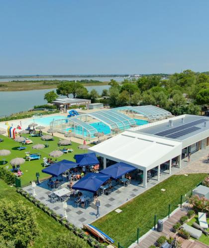 Piscina all'aperto vicino al lago con area relax e bar.