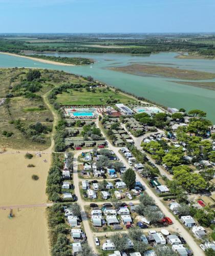 Vista aerea di spiaggia, campeggio e piscina vicino al mare.