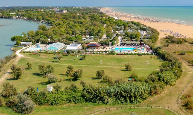 Strand mit Pools und Grün in einer Küstenlandschaft.