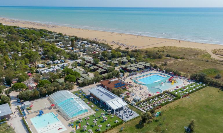 Vista aerea di un campeggio con piscine vicino alla spiaggia.
