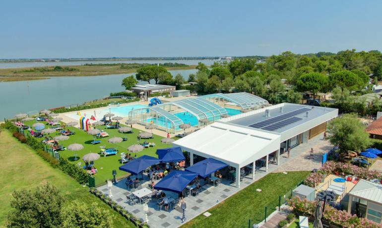 Buitenzwembad bij het meer met ontspanningsruimte en bar.