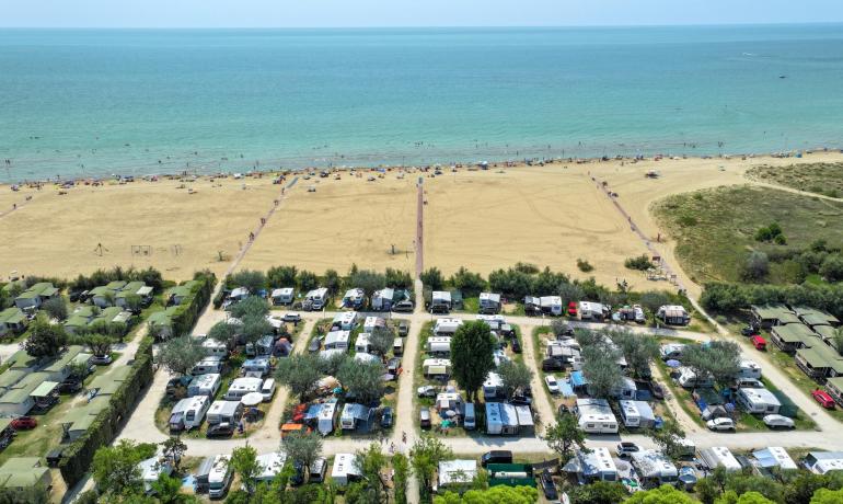 Campeggio vicino alla spiaggia con roulotte e tende.