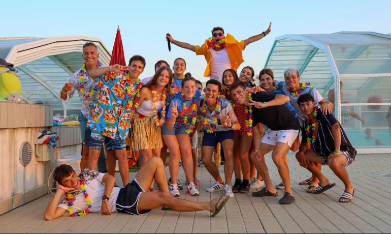 Gruppo di amici in festa con abiti hawaiani colorati.