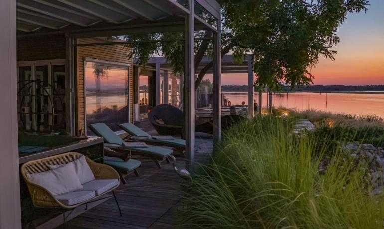 Terrazza moderna con vista lago al tramonto.